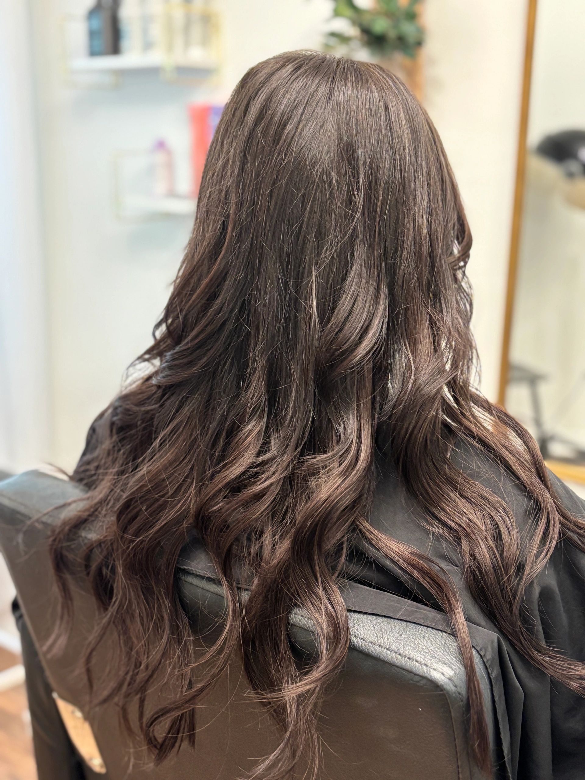 After extensions — long dark brown hair with caramel highlights